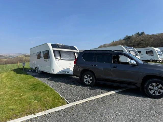 Touring caravan and tow vehicle on a rural pitch